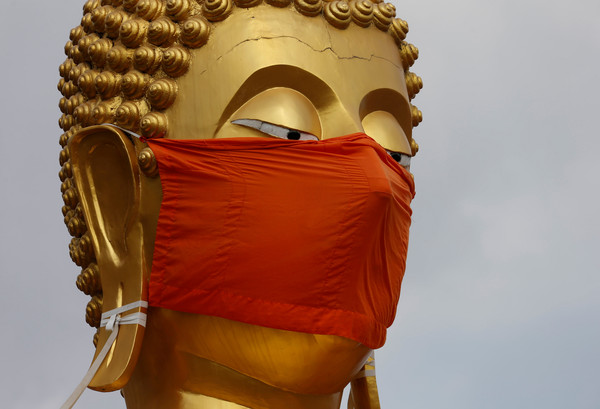 ▲▼泰國一處佛像配合防疫措施戴上了口罩。（圖／路透）