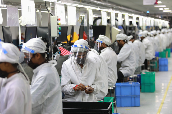 ▲▼印度鬆綁部分禁令後，手機裝配廠員工回到工廠上班，全程配戴口罩。（圖／路透）