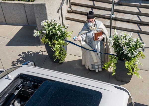 ▲▼牧師拿水槍向信徒噴射聖水。（圖／翻攝自Facebook／St. Ambrose Parish）