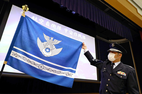 ▲日本防衛大臣河野太郎18日在成立儀式上， 展示「宇宙作戰隊」的旗幟。(圖／達志影像／美聯社)
