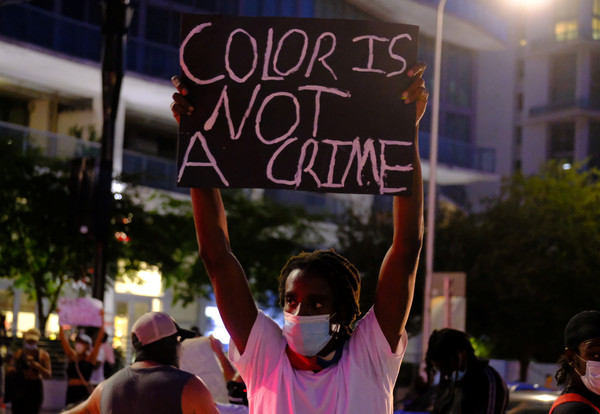 ▲▼ 佛洛伊德之死／佛州抗議民眾高舉「膚色不是犯罪」的標語。（圖／路透）