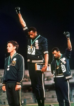 ▲▼        1968年墨西哥城奧運的黑人人權致敬事件照片，非裔美國籍選手史密斯（Tommie Smith）與卡洛斯（John Carlos）打赤腳上頒獎台，並在演奏美國國歌時高舉戴著黑色手套的右手。  。（圖／達志影像／美聯社）