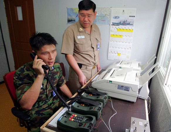 ▲▼ 2005年，南韓軍方人員在首爾以北的板門店與一名北韓軍方人員通話。（圖／路透）