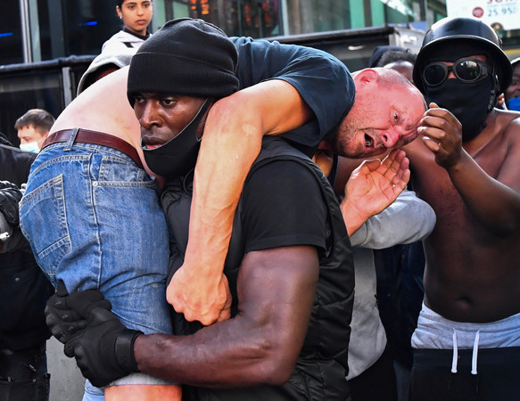 ▲▼非裔男子哈欽森（Patrick Hutchinson）扛起流血的白人男子，保護對方免於受到傷害。（圖／路透）