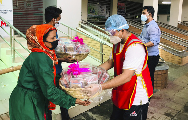 ▲孟加拉的新冠疫情嚴峻。圖為非營利組織的志工派送水果籃和慰問卡給確診者，為他們打氣。           。(圖／達志影像／美聯社)