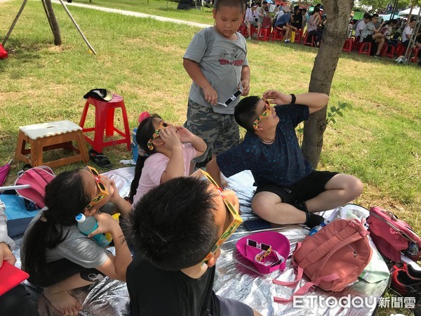 ▲▼嘉義公園有一家人提早來卡位，戴上有遮光效果的墨鏡要來看日環食。（圖／記者賴文萱攝）