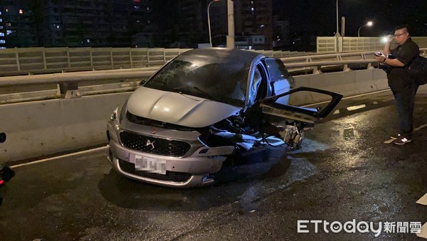 新北市板橋區23日凌晨2時許，一名男子駕著百萬雪鐵龍轎車，由東往西行經浮洲橋，途中因不明原因，突然撞上匝道分流護欄，車頭嚴重毀損，連輪胎都噴飛、輪框變形。警消獲報到場，協助駕駛脫困將他送醫，所幸全身僅多處擦挫傷無大礙。（圖／記者游宗樺攝）