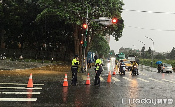 ▲2日午後大雷雨，造成桃園八德區部分街道淹水，四維派出所員警冒著大雨與雷殛危險指揮交通。（圖／記者沈繼昌翻攝）