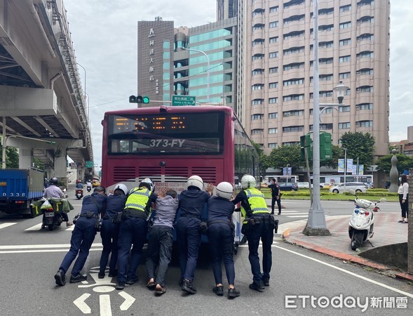 ▲▼公車拋錨在基隆路、敦化南路口，7名警員使盡吃奶力氣將車推到路邊待援。（圖／記者邱中岳翻攝）