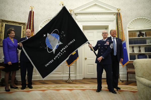 ▲今年5月時，美國總統川普(右)在橢圓形辦公室內向大家屉示「太空軍」的軍旗。（圖／達志影像／美聯社）