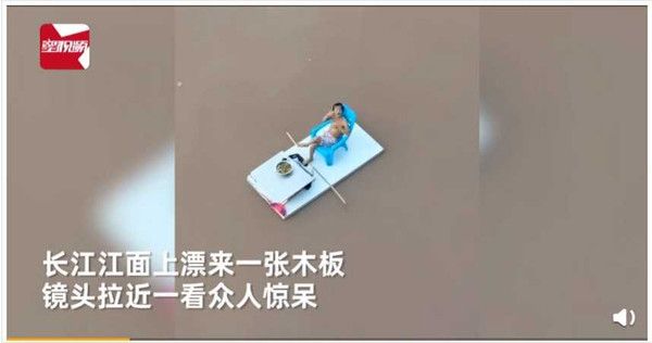 有男子搭乘棧板漂浮在長江江面上，一邊飲茶一邊隨波逐流。（圖／翻攝自頭條新聞微博）