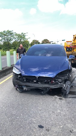 ▲特斯拉下交流道不熟路況，車頭全毀保險桿脫落。（圖／記者翁伊森翻攝）