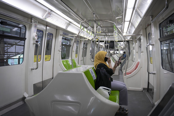 ▲▼ 馬來西亞首都吉隆坡一名戴口罩的女子在輕快鐵（LRT）車廂內使用手機。（圖／達志影像／美聯社）