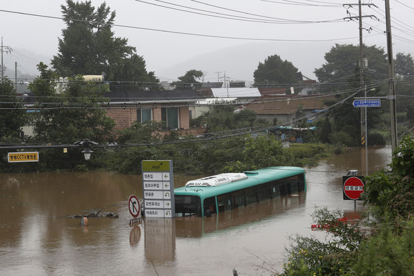 ▲▼南韓豪雨不斷，京畿道坡州市道路慘淹成運河，公車包括乘客浸泡水中。（圖／達志影像／美聯社）