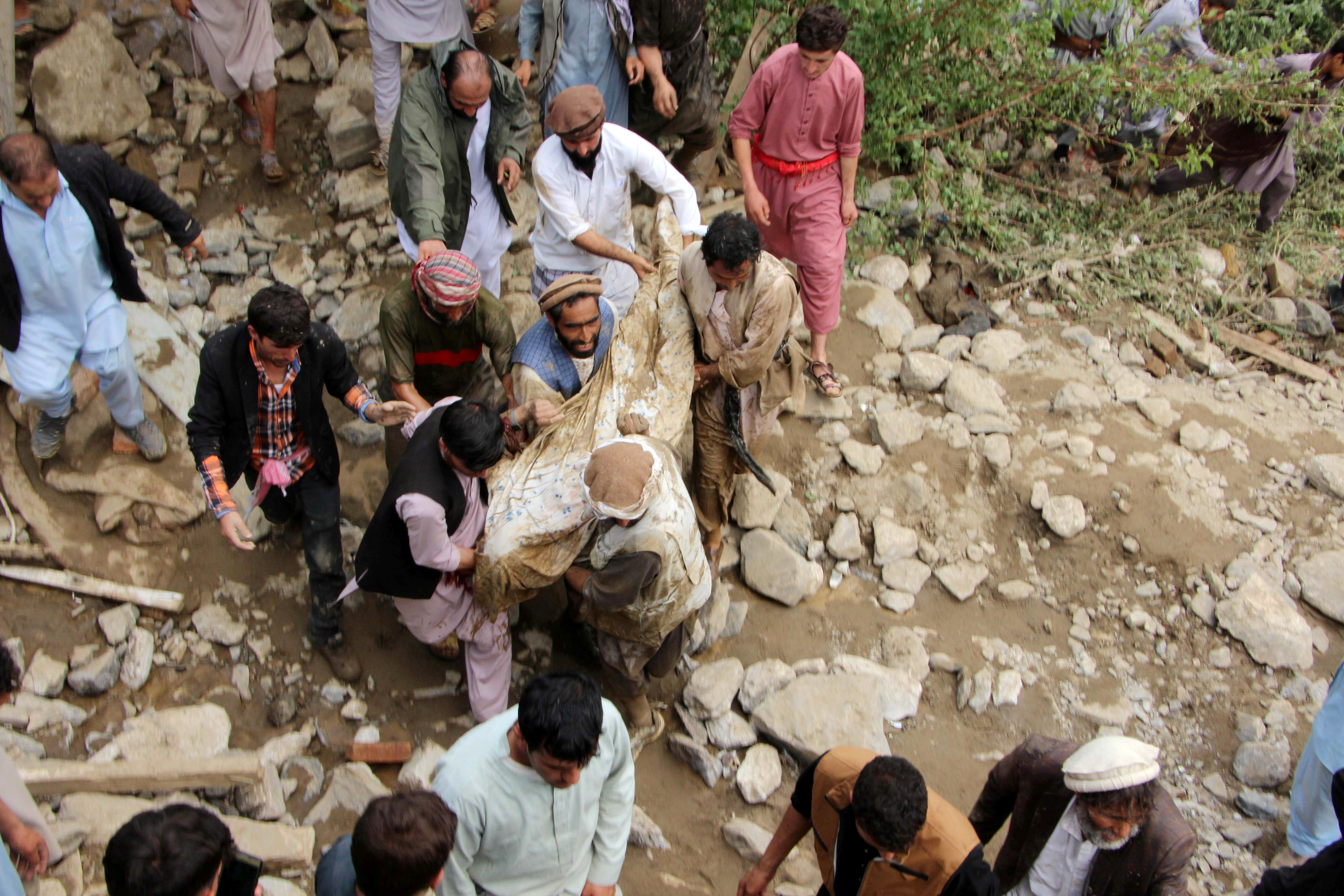 ▲▼阿富汗洪災過後，居民在一片混亂中抬出罹難者。（圖／路透）