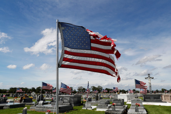 ▲▼強風撕裂了飄盪在公墓的美國國旗。（圖／路透）