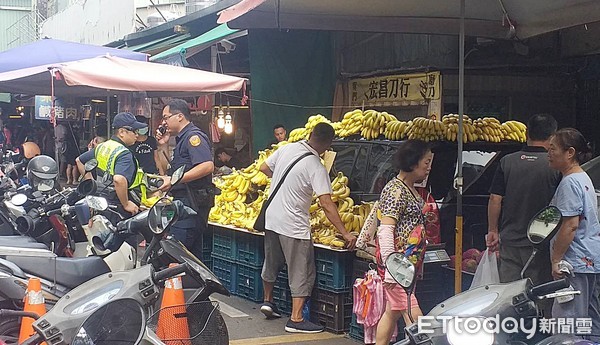 ▲桃園市南門市場11日上午有攤商將香蕉擺滿休旅車上，警方要求攤商將香蕉移出黃網線上。（圖／記者沈繼昌翻攝）