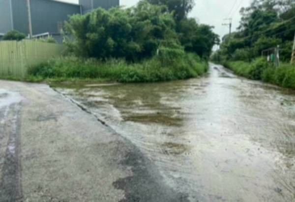 ▲涂權吉曝：道路淹水不退，為避水花攻擊，騎士晴天只好穿雨衣。（圖／市議會提供）