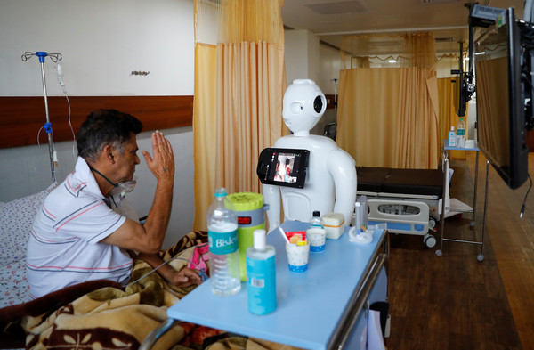 ▲▼印度北方邦諾伊達（Noida）一家醫院，新冠肺炎患者使用名為「Mitra」的機器人與家人交談。（圖／路透）