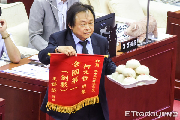 ▲台北市議會開議，民進黨議員王世堅送上饅頭及錦旗一面。（圖／記者林敬旻攝）
