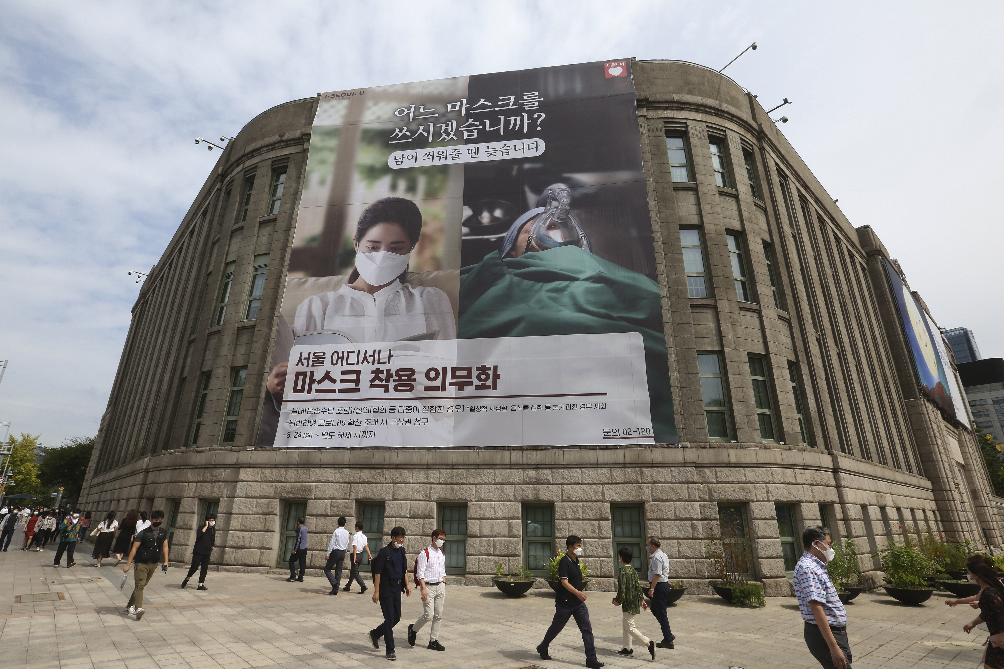 ▲▼舊首爾市廳外牆上掛起海報，宣導義務配戴口罩。（圖／達志影像）