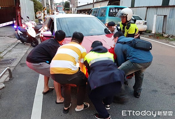 ▲平鎮警分局員警找來路人合力降故障轎車抬至路旁，紓解當地交通瓶頸。（圖／記者沈繼昌翻攝）