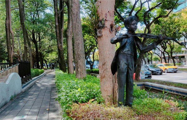 ▲士林區忠誠公園一帶可見整排的台灣欒樹，還有隨風起舞的舞者、拉著小提琴的小童裝置藝術。（圖／公園處提供）