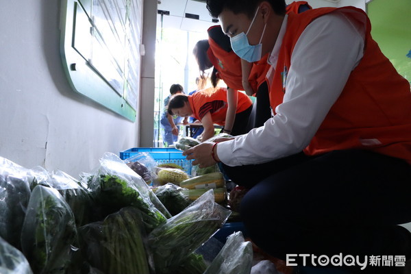 ▲志願者挑選菜籃裡的蔬果發送給需要幫助的清潔工。（圖／記者魏有德攝）
