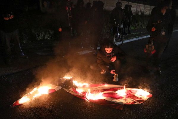 ▲▼憤怒的民眾在波特蘭市革命廳外燃燒國旗。（圖／路透）