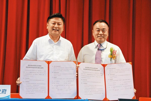 龍巖集團創辦人李世聰（右）在2015年捐贈5,000個納骨塔位給花蓮弱勢家庭，由時任花蓮縣長傅崐萁（左）代表接受。（資料照片）