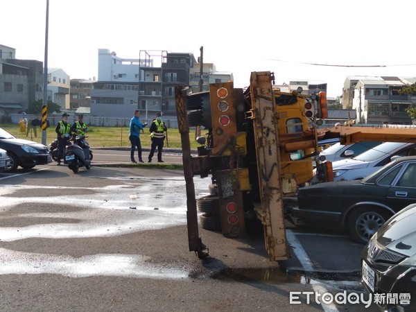 ▲台南市南區永吉街下午發生1起拖吊車翻覆事件，消防人員將大腿受傷變形的駕駛人以長板固定後，送醫就治，全案由市警六分局調查處理中。（圖／記者林悅翻攝，下同）