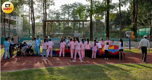 何爺爺志工團人手不足，高雄三民國小學童一起幫忙搬運各式氣墊到操場。（圖／宋岱融攝）