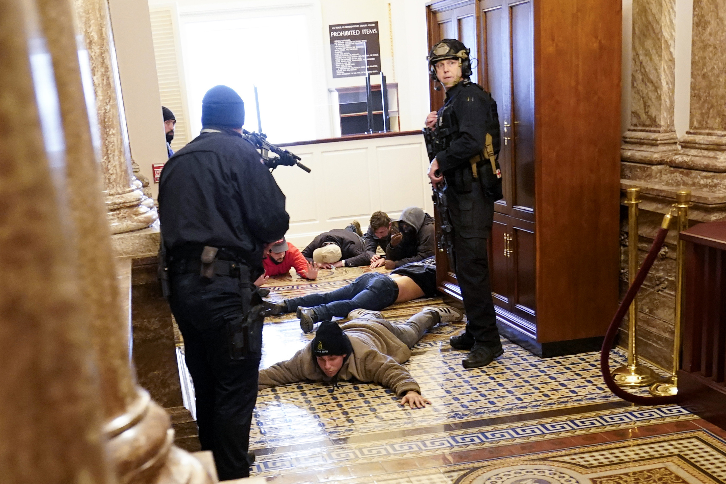 ▲▼ 川粉闖入國會大廈，議員被要求趴在位子上，國會警察持槍制伏暴動者。（圖／達志影像／美聯社）