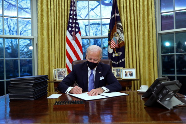 ▲▼ 美國總統拜登在橢圓辦公室簽署文件。（圖／路透）