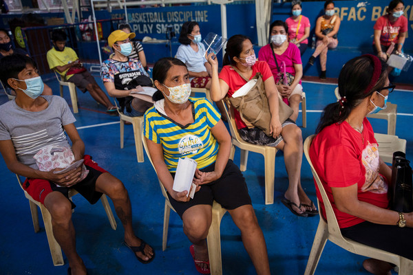 ▲▼　菲律賓孩童接種定期疫苗，當地醫療人員身穿防護服幫孩子施打。（圖／路透）