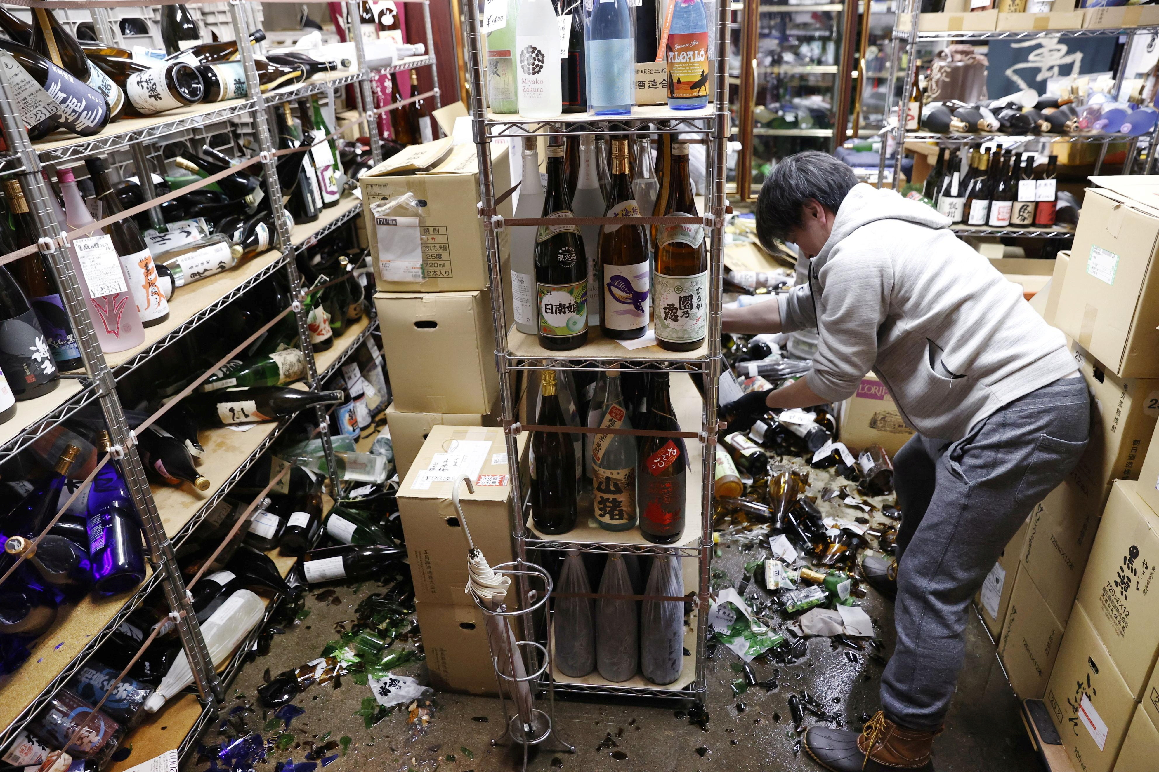 ▲▼日本地震，福島縣一處商店架上酒瓶摔碎一地。（圖／路透）