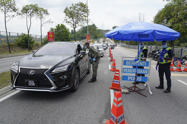▲馬來西亞警方在馬路上設置路障，維護防疫行動管制令。（圖／達志影像／美聯社）
