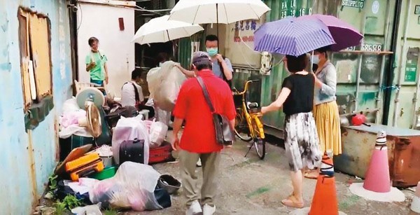 南港區公所協同各局處單位會勘後，協助住民將垃圾打包清出。（南港區公所提供）