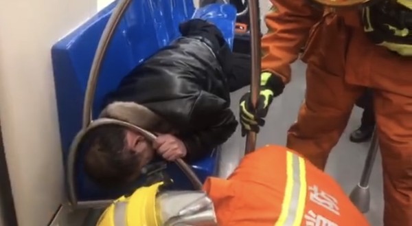 ▲上海一名醉男在地鐵車廂內打瞌睡，頭部卡進座椅扶手內。（圖／翻攝上海消防）
