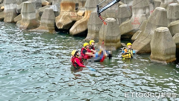 ▲金山磺港漁港驚見男浮屍卡消波塊　警消打撈上岸待指認。（圖／記者郭世賢攝）