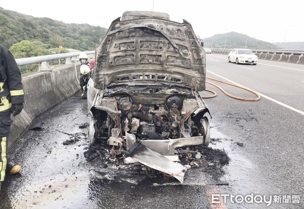 ▲中山高五楊高架南下桃園市蘆竹路段20日下午驚傳火燒車，消防人員10P 鐘撲滅火勢，但轎車僅剩焦黑骨架。（圖／記者沈繼昌翻攝）