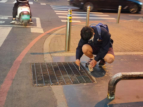 ▲台南一中學生蹲在路邊撿拾菸蒂，被路過民眾拍下PO文分享，受到網友狂讚分享。（圖／吳勝宏提供）