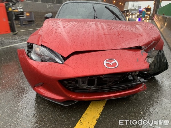 ▲1輛馬自達雙門敞篷車，因天雨路滑不慎失控自撞護欄，造成車頭損毀駕駛受傷送醫。（圖／記者黃孟珍翻攝）