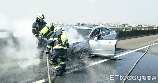 ▲1輛行駛國道2號桃園路段的轎車26日突然引擎冒火，瞬間轎車一片濃煙大火，消防人員現場灌救。（圖／記者沈繼昌翻攝）