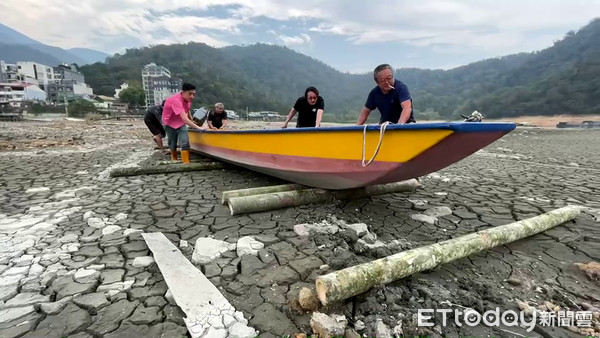 ▲伊達邵碼頭岸邊大面積乾涸裸露，船家得用圓木推船才能送上潭水。（圖／記者高堂堯翻攝）