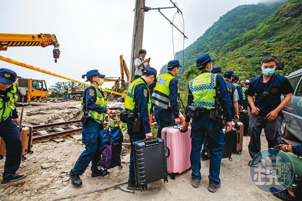 鐵路警察協助將乘客遺留在車廂內的行李箱搬出。