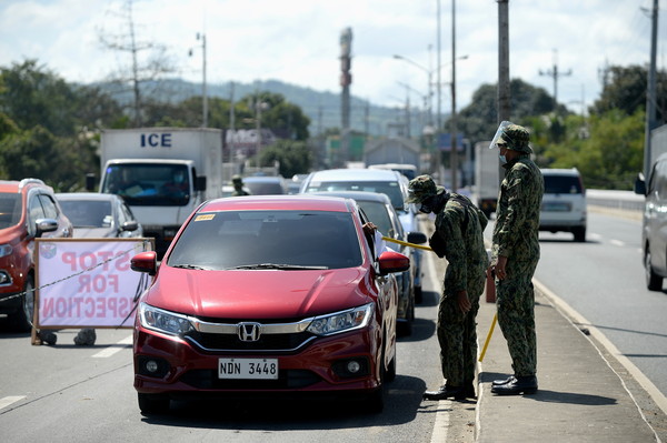 ▲▼菲律賓實施全國封鎖政策，首都馬尼拉的警察在路邊攔查車輛。（圖／路透）