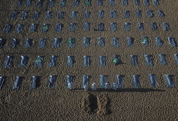 ▲▼ 巴西NGO團體「Rio de Paz」在海灘鋪上一排排塑膠袋，抗議巴西總統的新冠政策。。（圖／路透）
