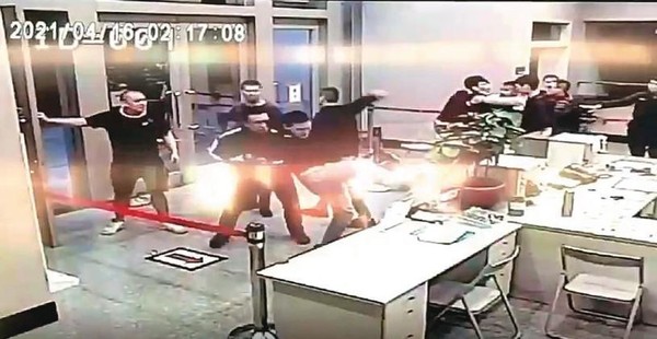 10名黑衣人在路上追打松山分局楊姓教官，並衝入派出所砸毀電腦。（翻攝畫面）