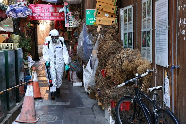 ▲▼ 台灣疫情升溫，軍人穿上防護衣在萬華執行消毒作業。（圖／路透）